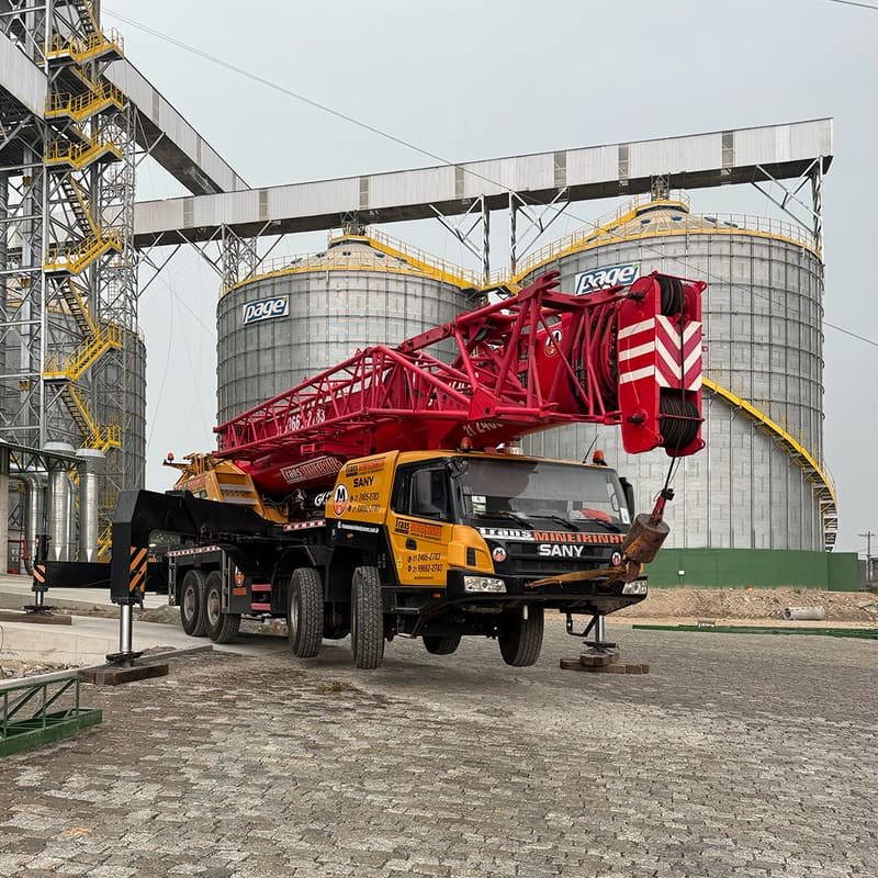 Guindaste Sany STC1000S da Trans Mineirinho ao lado de silos industriais no Rio de Janeiro